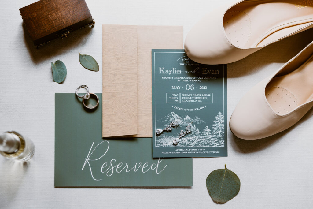 detailed flat lay wedding detail images featuring their wedding invitations, rings, perfumes, bridal shoes, and ring box