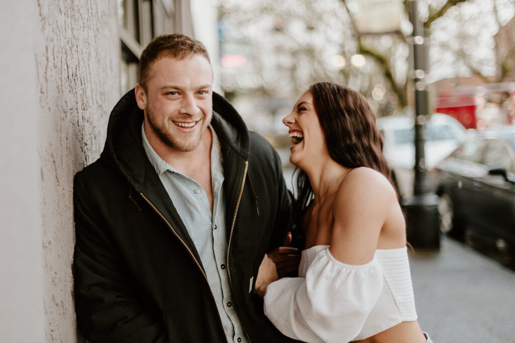Brandon and Courtney laughing together as they walk down the streets in downtown Camas