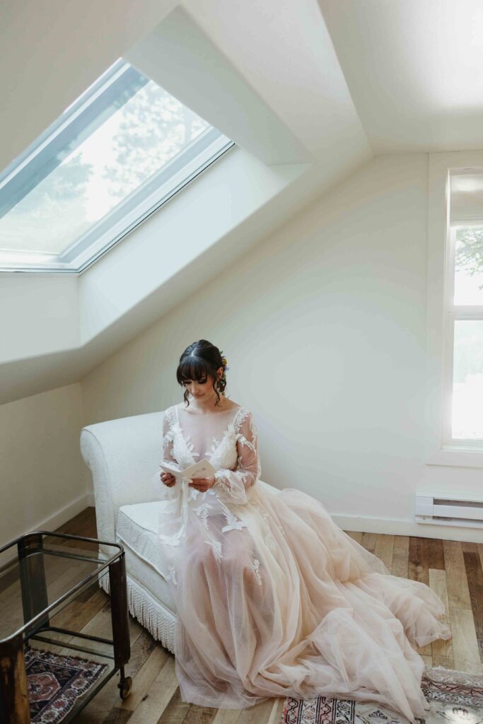 A bride in her wedding dress writing her vows in her bridal suite in Hood River, Oregon