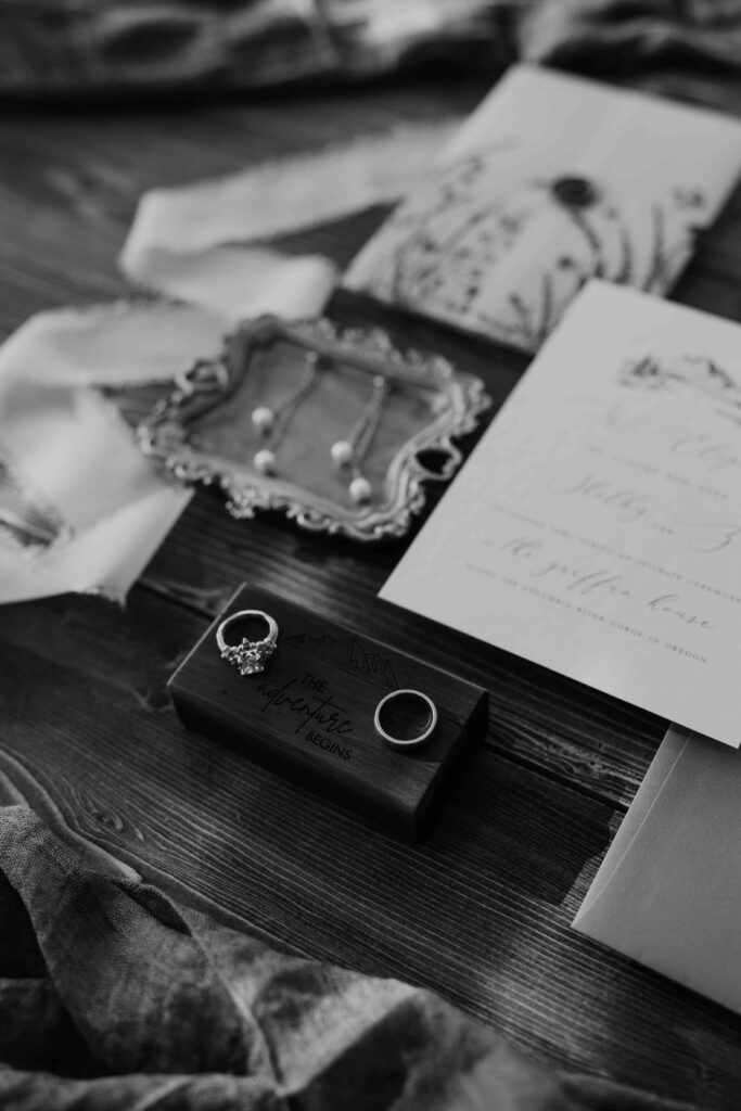 black and white elopement details with menu and rsvp on a table with the brides earrings and rings