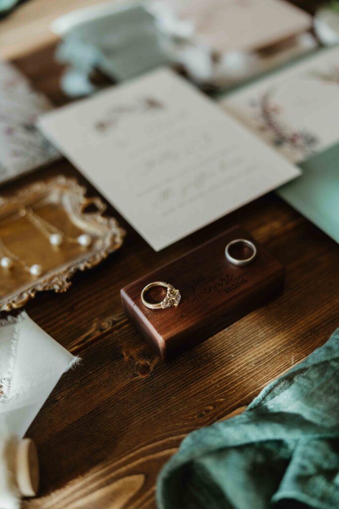 Close up of brides rings and wood engagement ring box