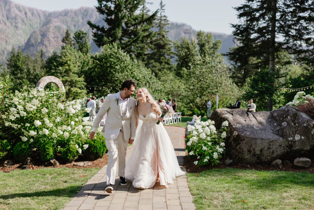 bride and groom meet for a kiss as they walk down the isle at their wedding date at Cape Horn Estate in Washington