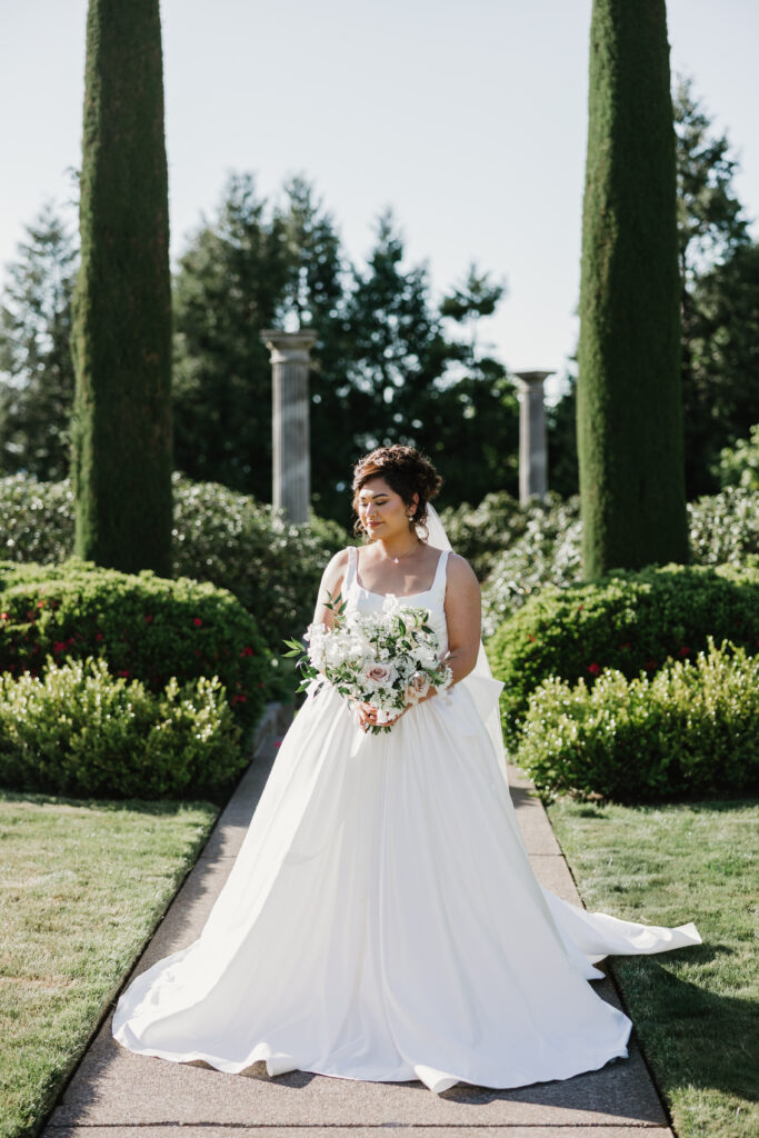 a bride photographed with her bridal bouquet and florals in a garden in the pacfic northwest