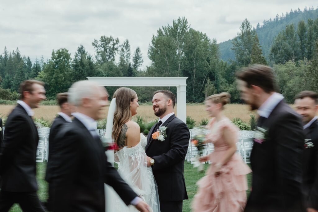Bridal party dances around a smiling bride and groom during their bridal party photos in Vancouver WA