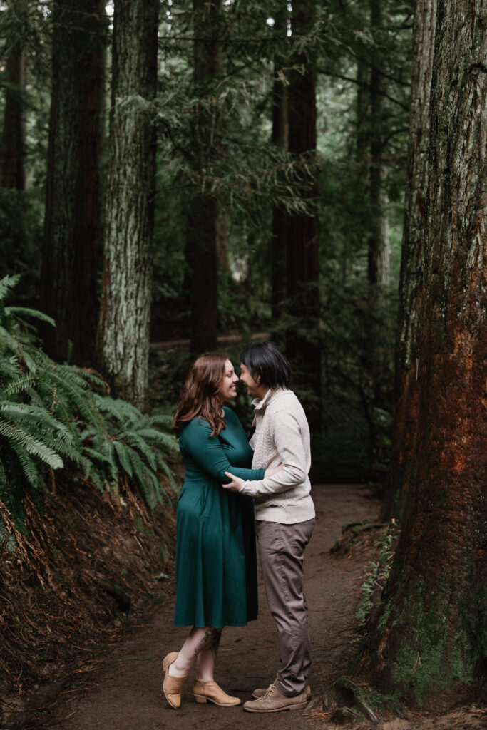Heather and Eric laughing together during rainy engagement photos in Portland OR