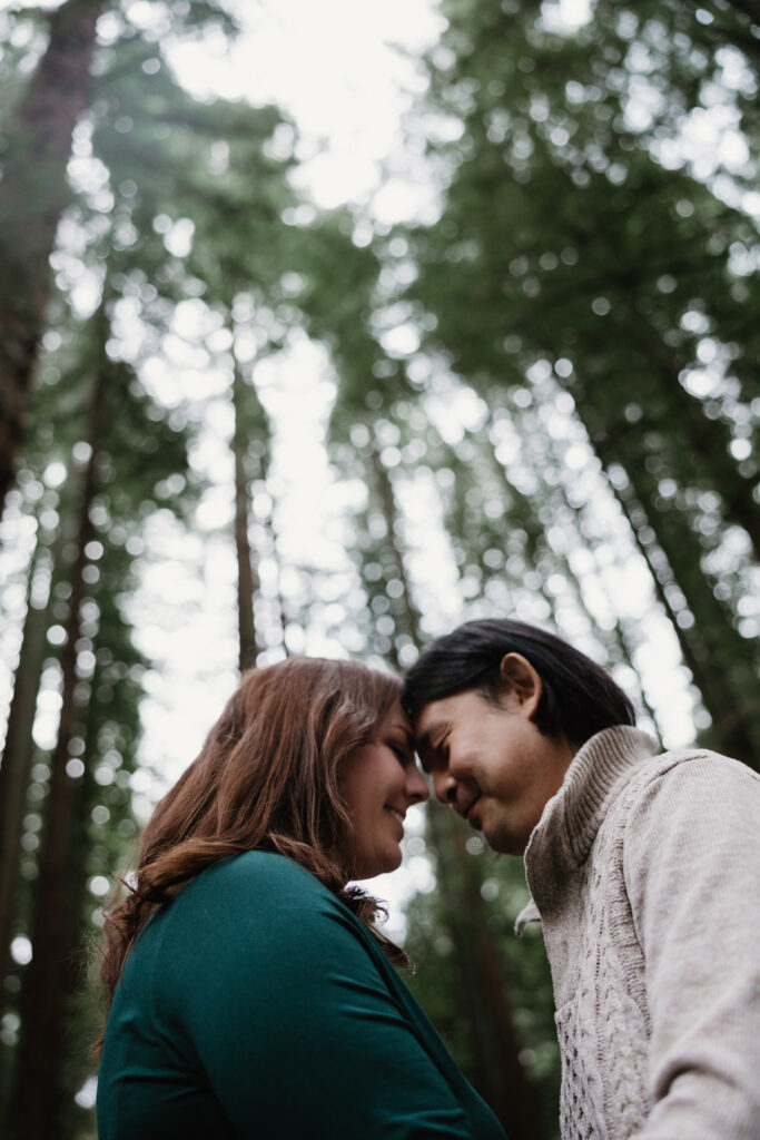 Romantic forehead touch during rainy Portland engagement photos with their Portland Engagement Photographer