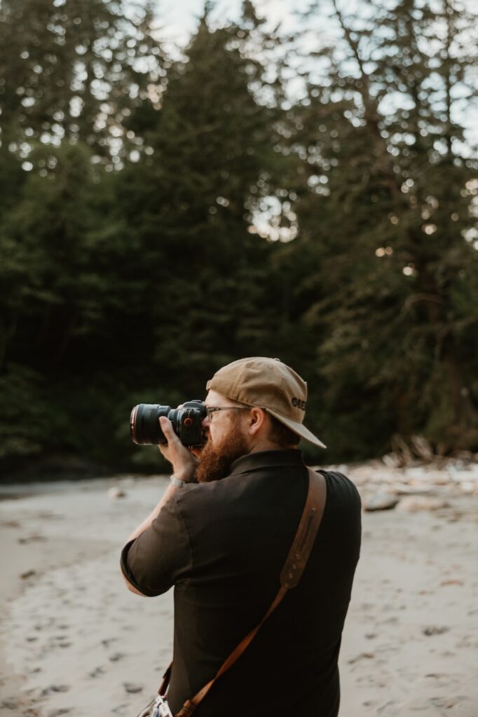 Lindsey and Hunter Wickert on location in the Columbia River Gorge, cameras in hand, photographing a couple's wedding day