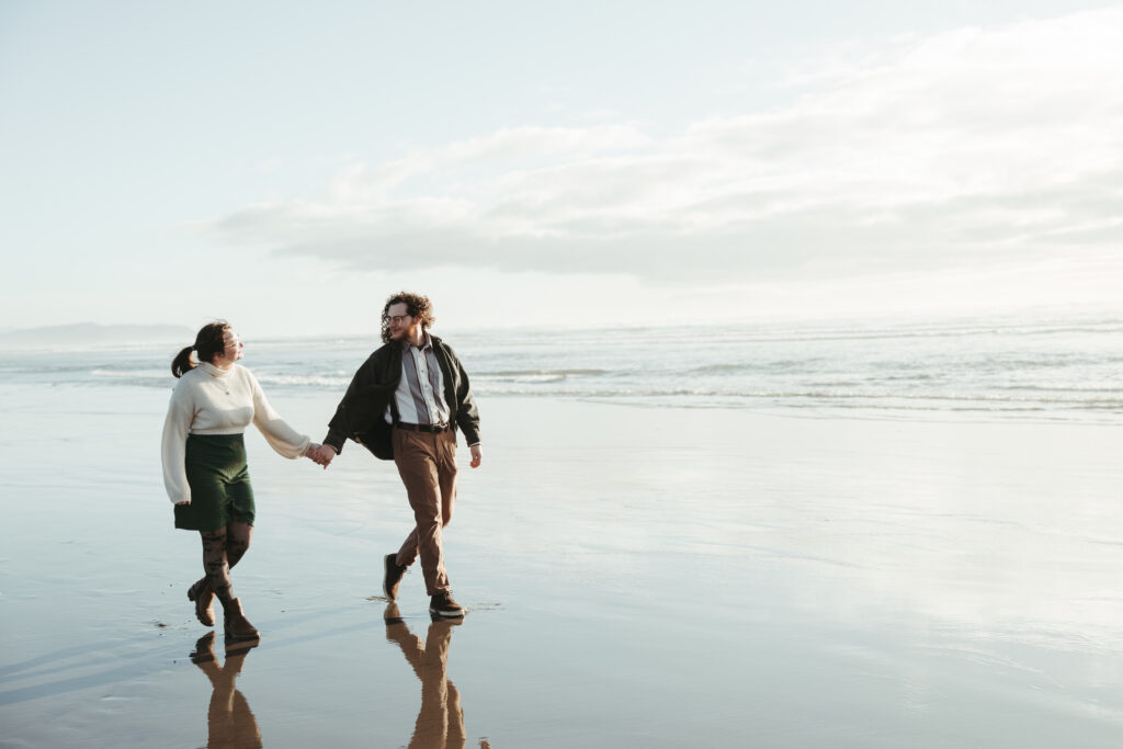 Couple laughing together on the beach at Fort Stevens during Oregon Coast engagement session