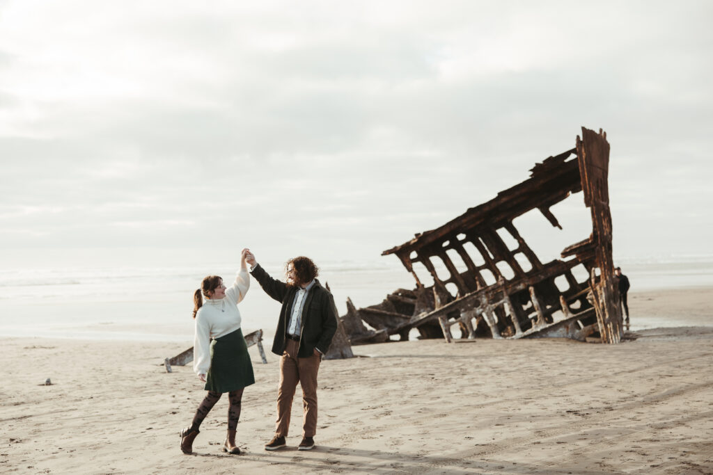 Couple embracing at the Wreck of the Peter Iredale during engagement session in Astoria Oregon
