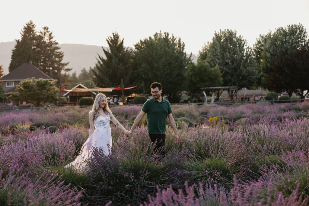 Wide shot of couple embracing in purple lavender rows under wildfire smoke haze near Hood River Oregon — The Wickerts Photography