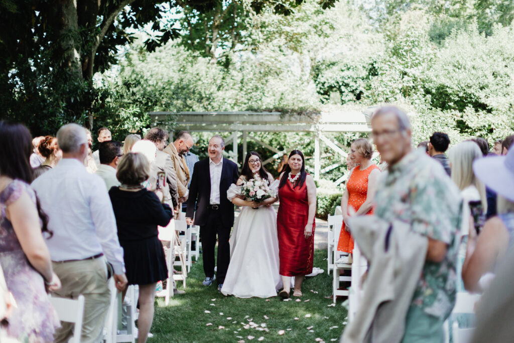 Bride walking down the outdoor ceremony aisle at Deepwood Museum and Gardens in Salem, Oregon