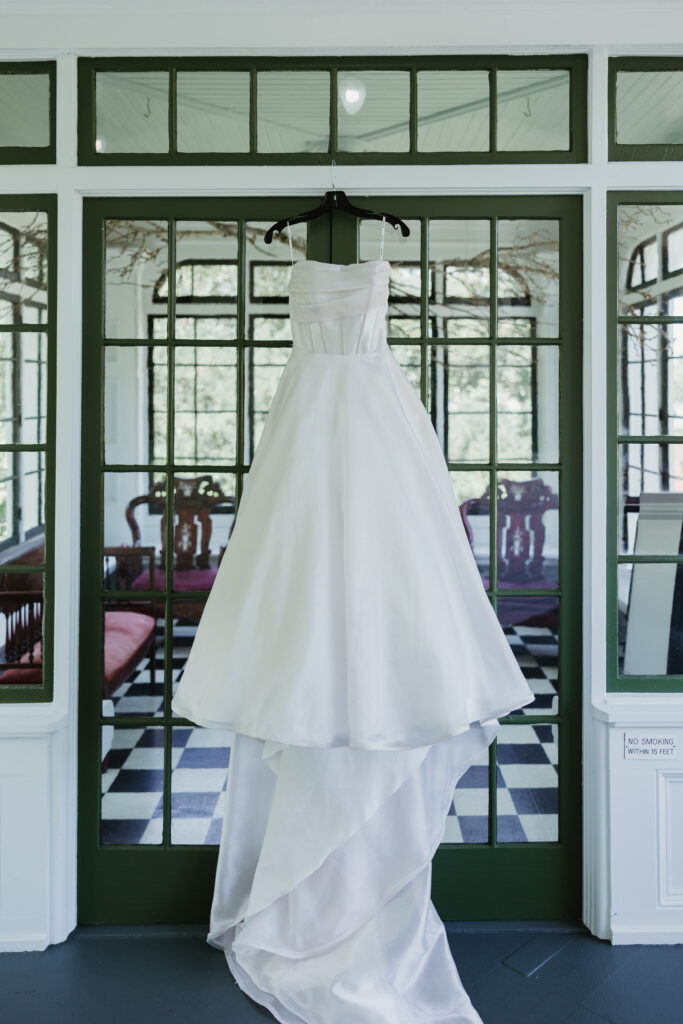 Bride's wedding dress hanging in a window at Deepwood Museum and Gardens in Salem, Oregon