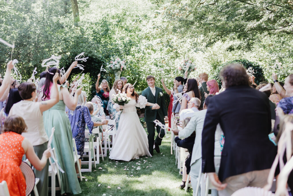 Bride and groom celebrating with their guests as they exit their wedding ceremony at Deepwood Museum and Gardens in Salem OR