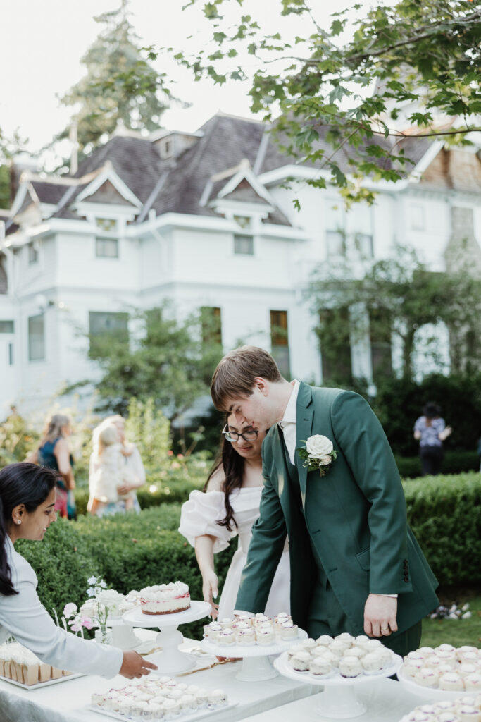 Bride and groom cut the cake together during their reception at Deepwood Museum and Gardens