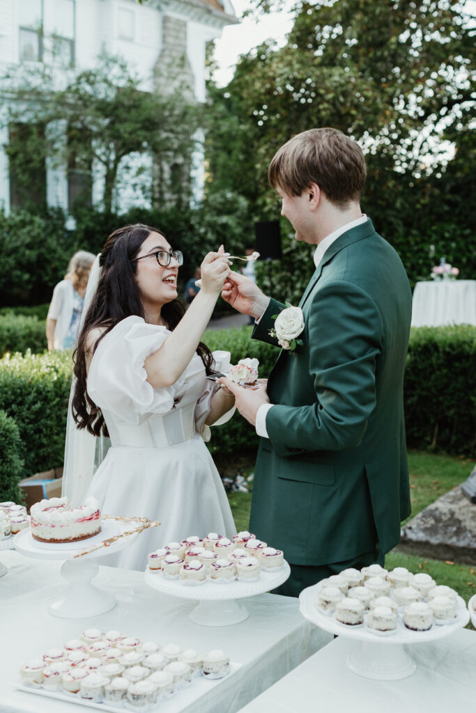 Bride and groom share their first bite of wedding cake at Deepwood Museum and Gardens