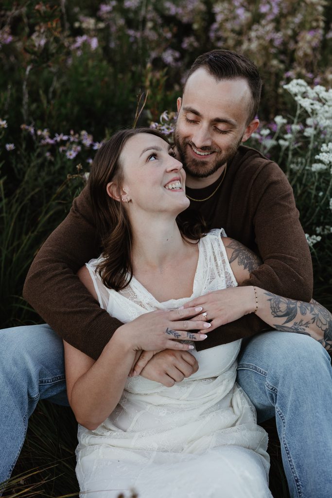 Couple smiling together in a field of wildflowers