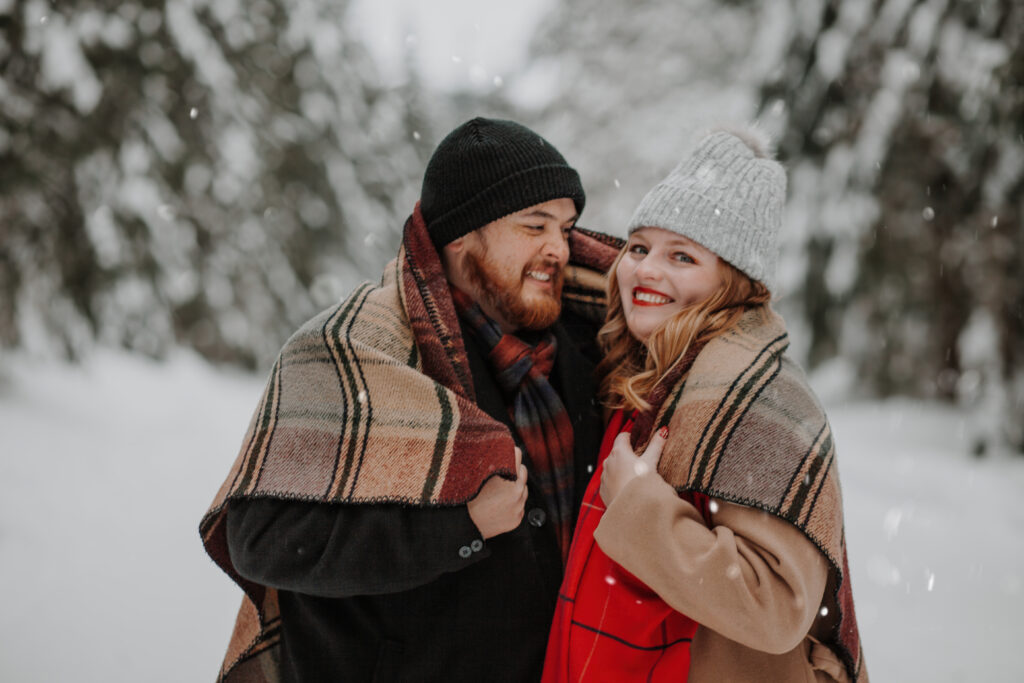 blanket up and staying warm in their snowy december engagement session