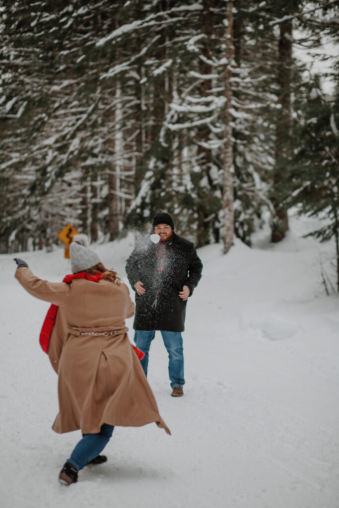 alysa throws a snowball at her new fiance during their playful engagement session